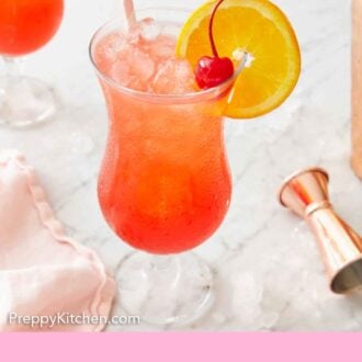 Pinterest graphic of a glass of hurricane drink with a straw, cherry, and orange slice in the drink.