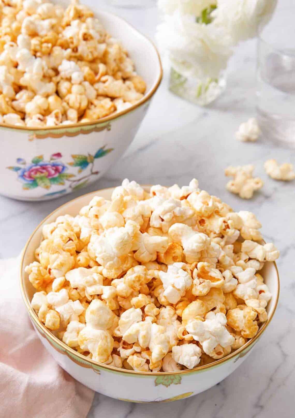A bowl of kettle corn with a larger bowl in the background.