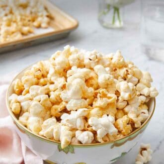 Pinterest graphic of a bowl of kettle corn with more scattered on the side.