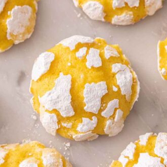 Multiple lemon crinkle cookies with one in the middle, in focus.