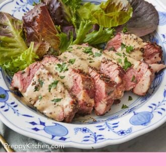 Pinterest graphic of a plate with sliced steak au poivre with mixed greens beside it.