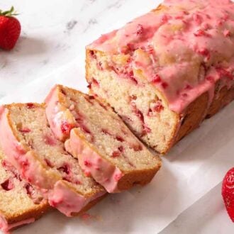 A strawberry bread with three slices cut off.
