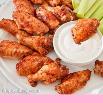 Pinterest graphic of a platter of chicken wings with one placed inside a bowl of dip.