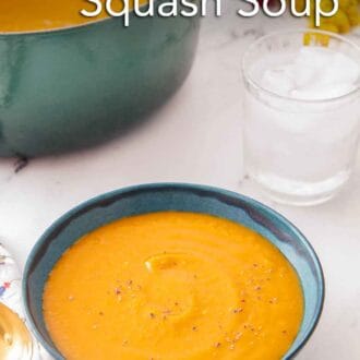Pinterest graphic of a bowl of butternut squash soup with a glass of water and pot with the rest of the soup behind it.