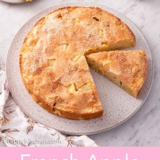 Pinterest graphic of a slightly overhead view of a round French apple cake with a slice plated in the background and another slice cut.