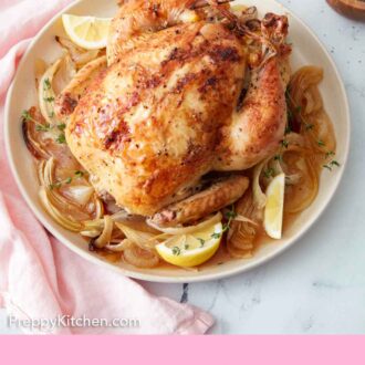 Pinterest graphic of a plate of lemon wedges, thyme, and cooked onions underneath a roasted chicken.
