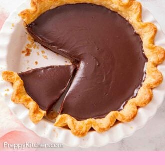 Pinterest graphic of an overhead view of a white baking dish with a chocolate pie with a slice removed and a slice cut.