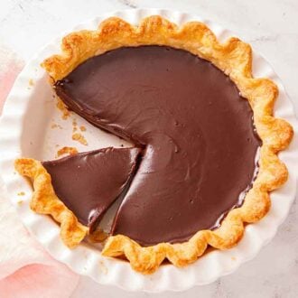 Overhead view of a chocolate pie with a slice removed and a second slice cut.