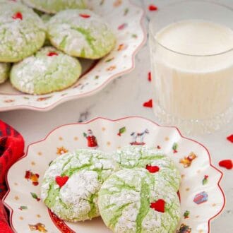 Pinterest graphic of a plate of three Grinch cookies with a glass of milk and another cookie platter in the back.