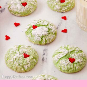 Pinterest graphic of five Grinch cookies on a marble counter with a glass of milk on the side.
