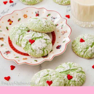 Pinterest graphic of a plate with Grinch cookies with more scattered around the plate along with a glass of milk.