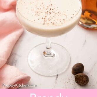 Pinterest graphic of a glass of Brandy Alexander with two pieces of nutmeg beside it.