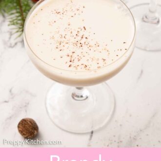 Pinterest graphic of a coupe glass of Brandy Alexander with freshly shaved nutmeg on top.