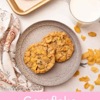 Pinterest graphic of an overhead view of a plate with two cornflake cookies with a glass on milk and sheet pan of cookies.