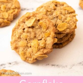 Pinterest graphic of a cornflake cookie leaned up against a stack of cookies with more in the background.