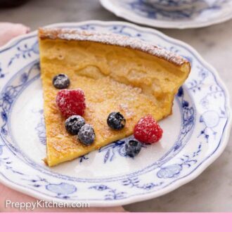 Pinterest graphic of a slice of Dutch baby with a couple of blueberries and raspberries on top.
