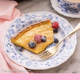 Pinterest graphic of of a half eaten slice of Dutch baby on a plate with a fork on it and some berries on top.