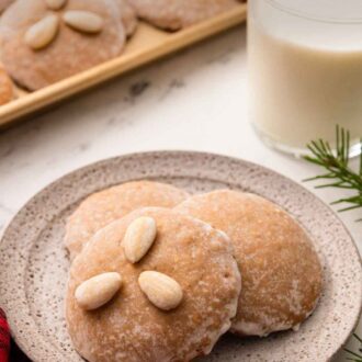 Pinterest graphic of three Lebkuchen on a plate with a glass of milk behind it and with more cookies.