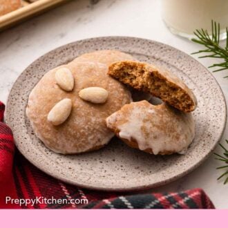 Pinterest graphic of a plate of Lebkuchen with one broken in half and a glass of milk in the background.