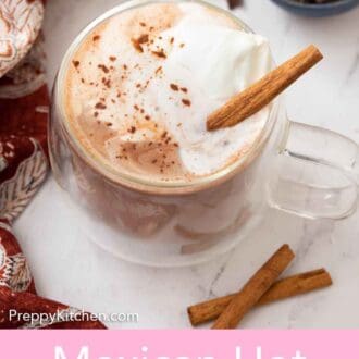 Pinterest graphic of a mug of Mexican hot chocolate with whipped cream and a cinnamon stick on top with some more chocolate in the back and cinnamons sticks in the front.