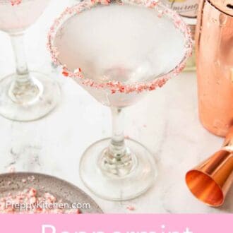 Pinterest graphic of a peppermint martini with a shaker, bottles of alcohol, and a second martini glass behind it.