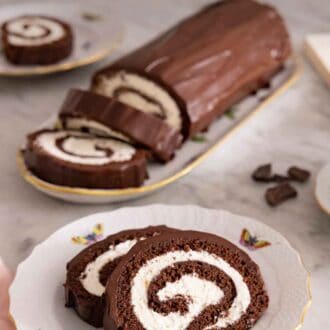 Pinterest graphic of a plate with two slices of Swiss roll with the cut roll in the background.