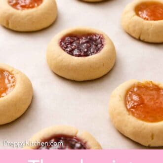 Pinterest graphic of multiple thumbprint cookies on a white surface.