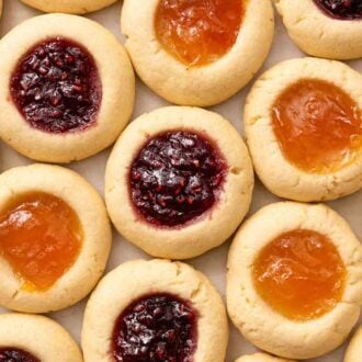 Overhead view of thumbprint cookies in a single layer, with two different jam fillings.