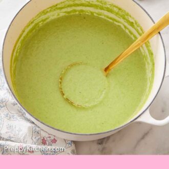 Pinterest graphic of a white dutch oven of asparagus soup with a gold colored ladle inside.