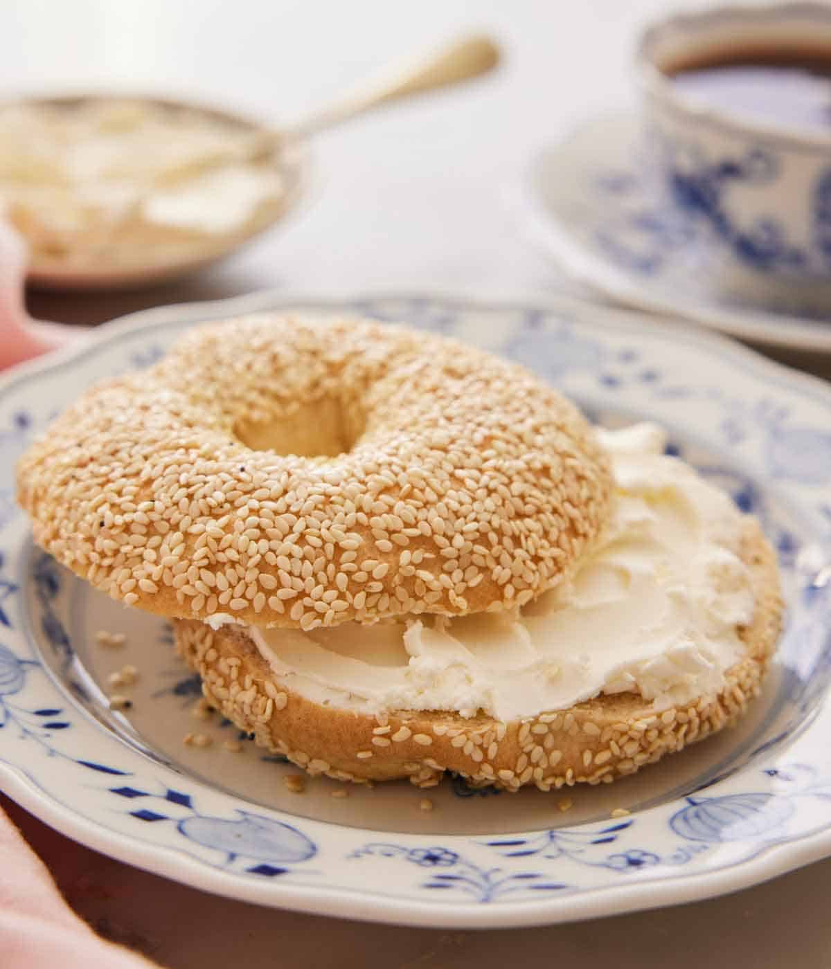 A bagel cut in half with cream cheese smeared in the middle.