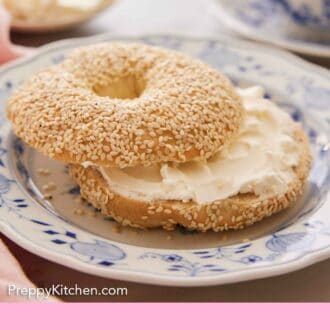 Pinterest graphic of a sliced bagel with cream cheese in the middle on a plate.
