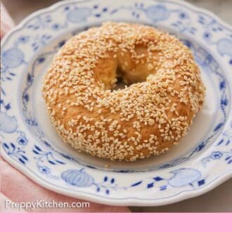 Pinterest graphic of a sesame covered bagel on a plate patterned plate.