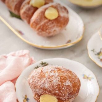 Pinterest graphic of a plate with a bomboloni with a platter with more in the background.