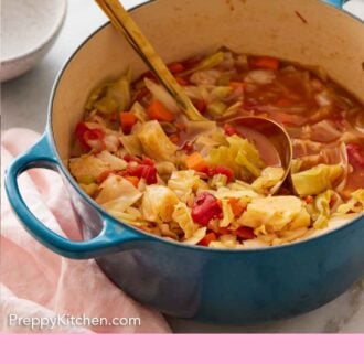 Pinterest graphic of a blue pot of cabbage soup with a ladle inside.