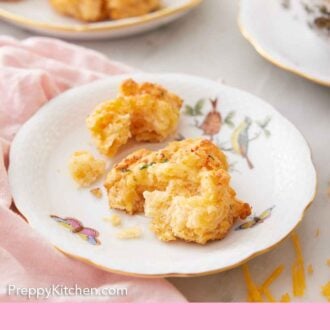 Pinterest graphic of a plate with a torn piece of cheddar biscuit.