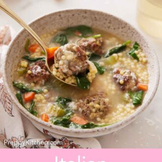 Pinterest graphic of a bowl of Italian wedding soup with a spoonful lifted up containing a meatball.