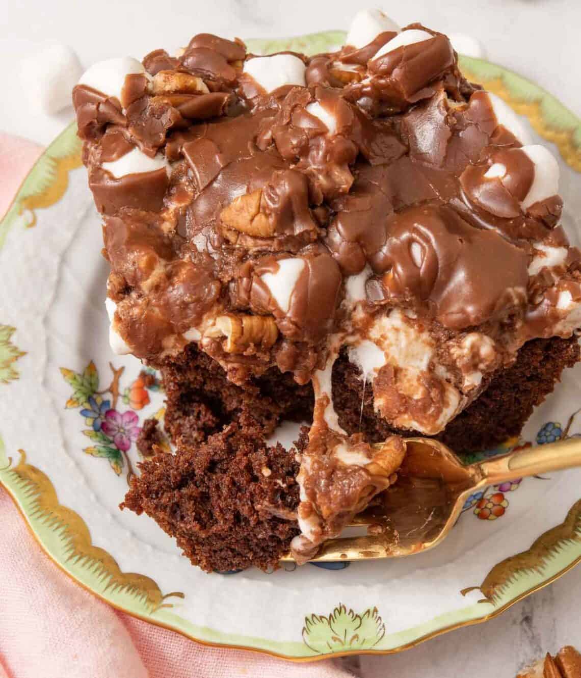 Close up view of a slice of Mississippi mud cake with a fork breaking off a bite.