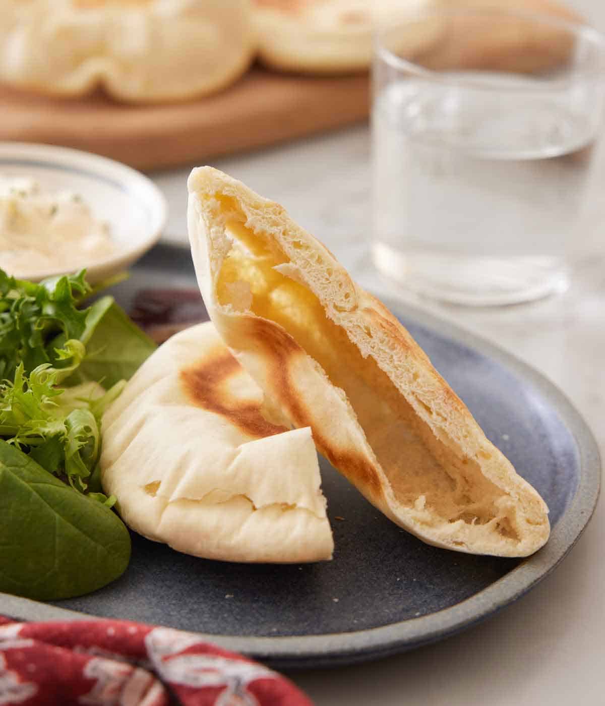 A plate with a pita bread cut in plate, showing the hollow inside.
