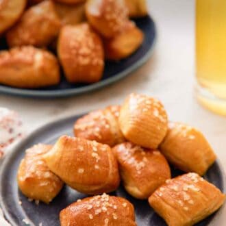 Pinterest graphic of a plate of pretzel bites with a platter with more in the back along with a drink.