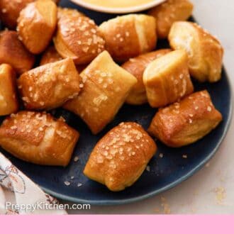 Pinterest graphic of a platter of pretzel bites with a bowl of dip in the back.