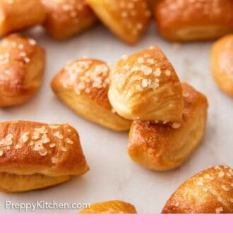 Pinterest graphic of pretzel bites scattered on a surface with one stacked on top of two pretzel bites.