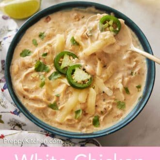 Pinterest graphic of a bowl of white chicken chili with a spoonful being lifted from it.