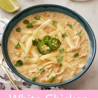 Pinterest graphic of a bowl of white chicken chili with three sliced jalapeno, shredded cheese, and chopped cilantro on top.