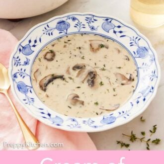 Pinterest graphic of a bowl of cream of mushroom soup with a glass of wine and a white pot in the background.