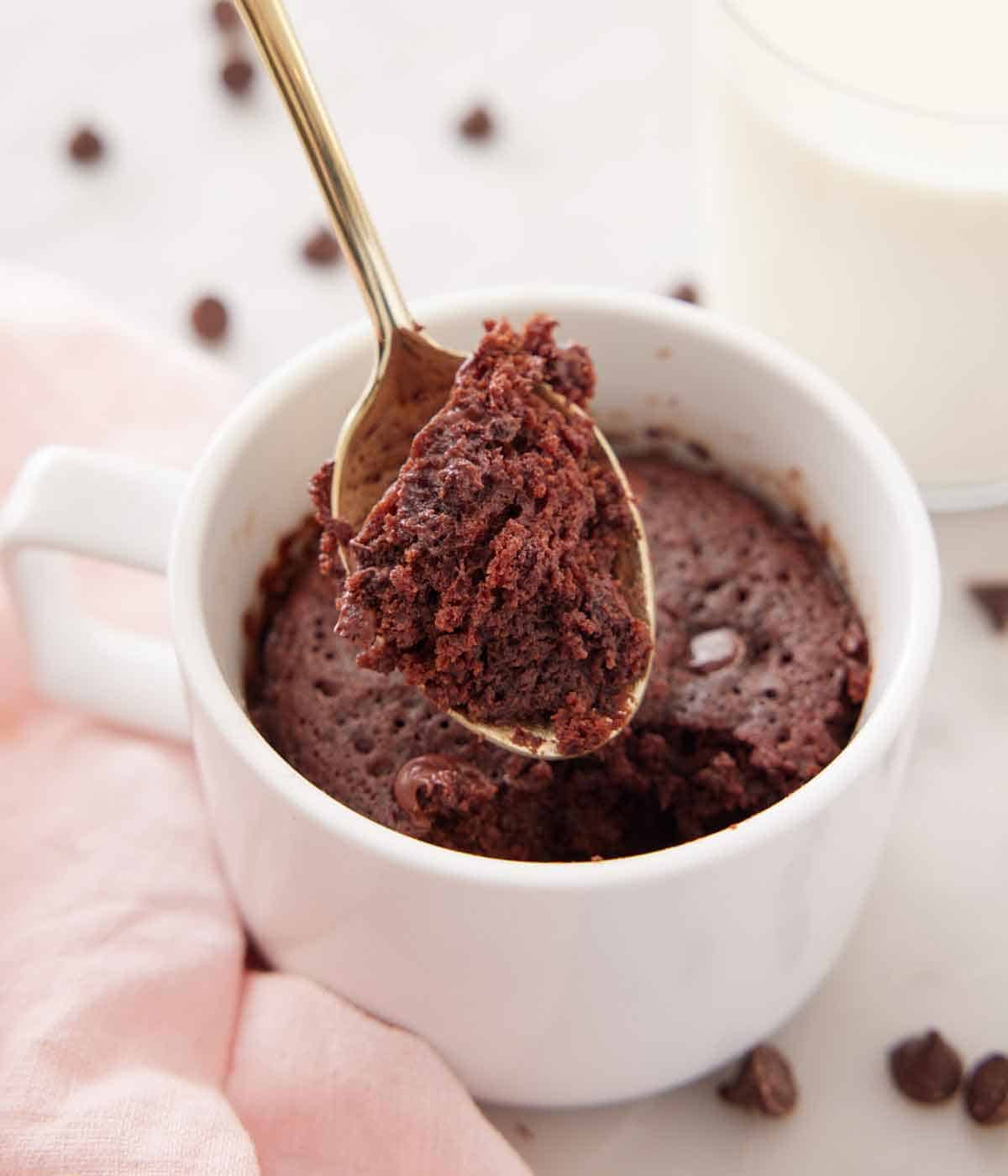 A spoonful of mug cake lifted out of the cup.