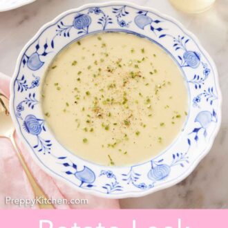 Pinterest graphic of a bowl of potato leek soup with chopped chives and pepper on top with a glass of wine in the back.