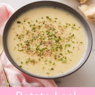 Pinterest graphic of a bowl of potato leek soup with chives and pepper with some torn bread in the background.