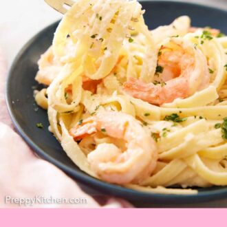 Pinterest graphic of shrimp Alfredo pasta being lifted from a plate.