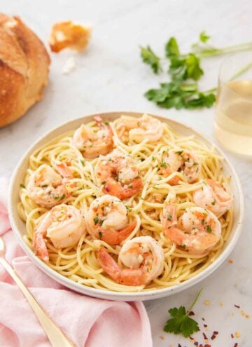A bowl of pasta noodles topped with shrimp scampi.
