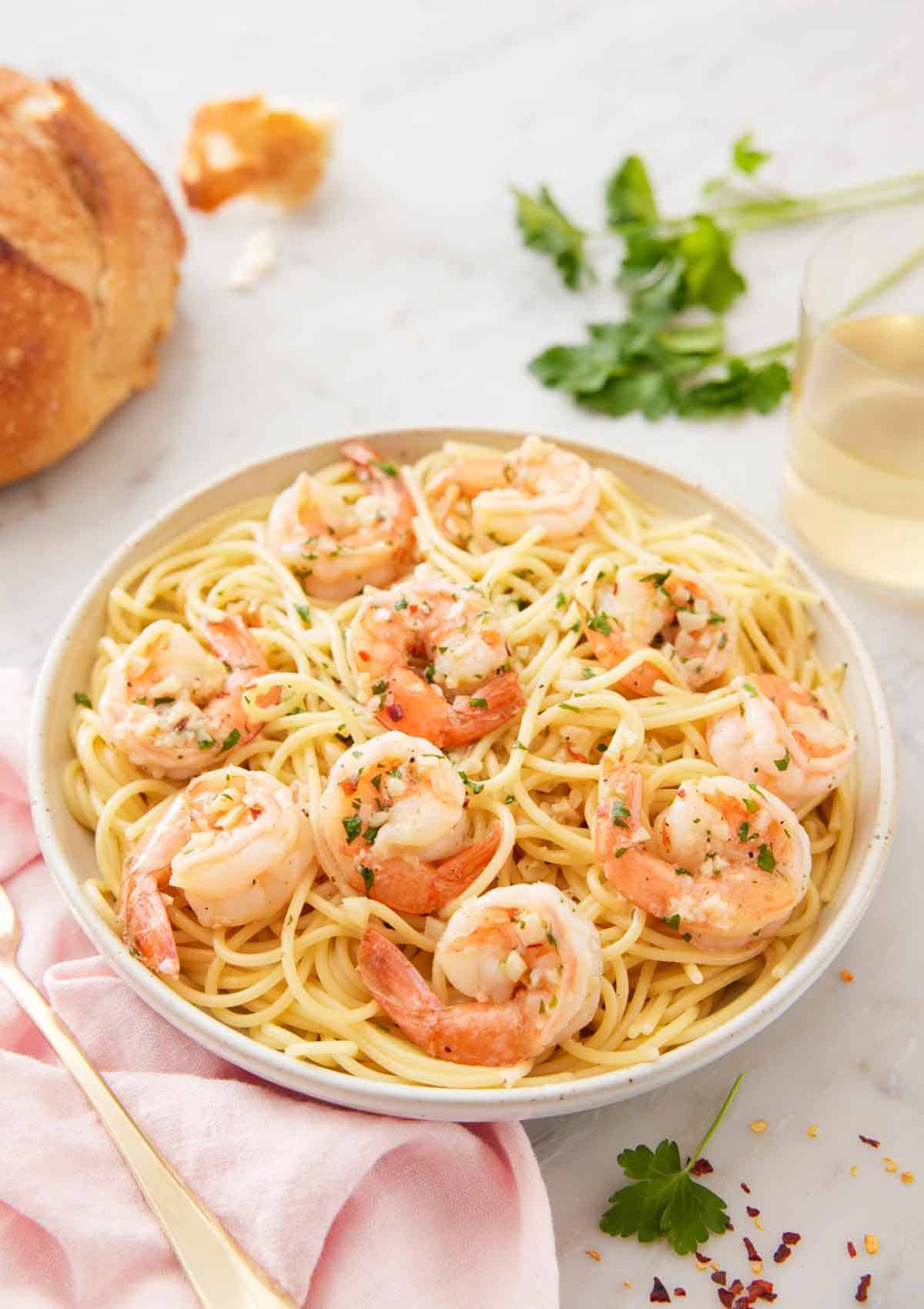 A bowl of pasta noodles topped with shrimp scampi.